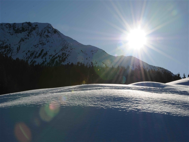 I raggi del sole illuminano dune di neve creando stupendi effetti di luce ed ompra.